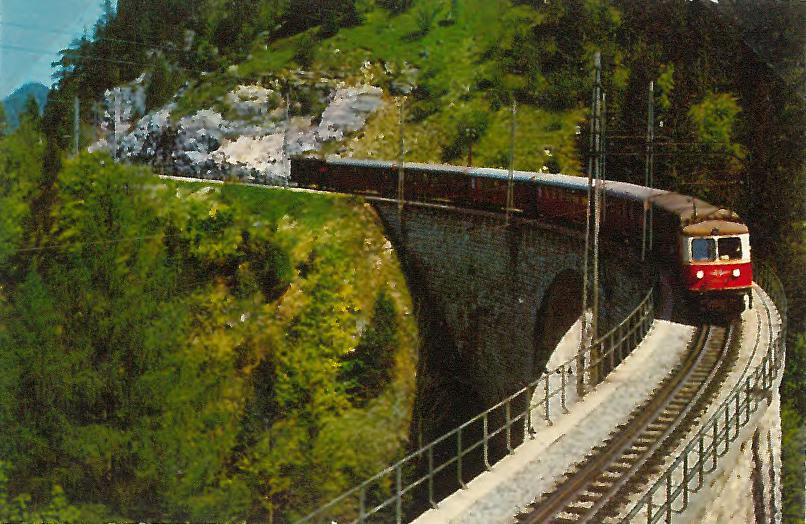 Eisenbahnzug fährt über Bergbrücke