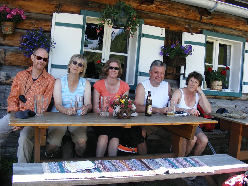 5 TeilnehmerInnen sitzen auf der Hüttenbank zur Rast