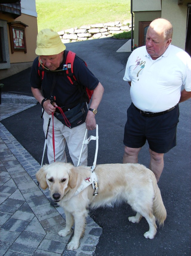 Blinder mit seinem Führhund und Begleiter